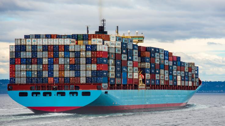 A picture of a shipping container fully loaded with containers at sea